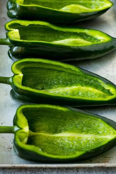 several green peppers sitting on top of a metal tray