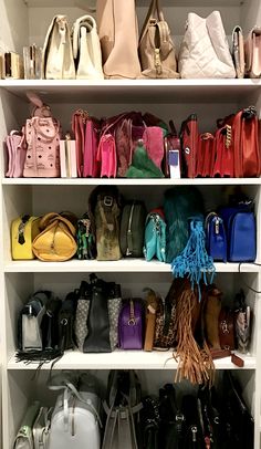 a closet filled with lots of purses and handbags on top of white shelves