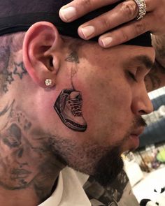 a man with tattoos on his face and neck