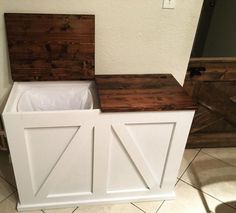 a white storage box with two doors on the top and bottom, in front of a wall