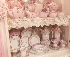 a shelf filled with pink and white china