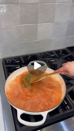 a person stirring food in a pan on the stove