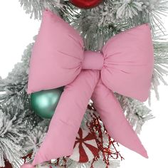 a pink bow on top of a christmas tree