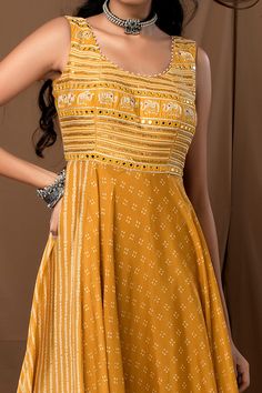 Mustard anarkali with bandhani prints, bias cut hem and heavy embroidery on the yoke and tassels at the back.
Component: 1
Pattern: Printed
Type Of Work: Bandhani
Neckline: U-neck
Sleeve Type: Sleeveless
Fabric: Cotton Silk
Color: Yellow
Other Details: 
Back cut-out with tassel tie-up
Elephant motifs on yoke
Cluster bead embellished neckline
Occasion: Puja - Aza Fashions Mustard Anarkali, Printed Anarkali, Embellished Neckline, Heavy Embroidery, U Neck, Anarkali, Cotton Silk, Aza Fashion, Silk Printing