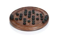 a wooden board game with black marbles on it