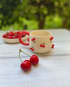 two cups with cherries are sitting on a table