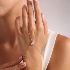 This beautiful hand chain is crafted from sterling silver and features a dainty chain. The centerpiece of the chain showcases a stunning heart-shaped zircon gemstone, exuding a casual yet sophisticated vibe. Show off your romantic side (without being cheesy) with this delicate design. Metal: 925 sterling silver Finish: 18k gold Gemstone: white zirconia Bracelet length: adjustable with 4 cm extender (1.5") Chain: cable link Clasp: spring ring Hypoallergenic, nickel-free Don’t forget, proper care Adjustable Heart-shaped Diamond Jewelry, Heart-shaped Chain Jewelry For Weddings, Elegant Adjustable Cubic Zirconia Heart Bracelet, Elegant Adjustable Heart Bracelet With Cubic Zirconia, Elegant Cubic Zirconia Heart Bracelet Gift, Adjustable Cubic Zirconia Heart Bracelet For Party, Adjustable Heart-shaped Cubic Zirconia Jewelry, Adjustable Heart Cut Cubic Zirconia Jewelry, Adjustable Heart Shaped Cubic Zirconia Jewelry