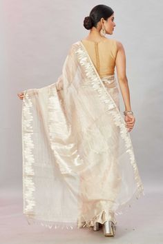 The charm of this cream tissue Banarasi sari is sure to leave everyone awestruck! It is enhanced with zari work and comes with a matching blouse piece. Disclaimer: The shown stitched blouse on the model is for display purpose only. The saree comes with a matching blouse piece and finished with fall and piko. Festive Beige Blouse Piece With Traditional Drape, Beige Semi-stitched Saree, Beige Pre-draped Saree, Designer Raw Silk Cream Saree, Designer Cream Raw Silk Saree, Traditional Drape Art Silk Blouse Piece In Cream, Cream Art Silk Saree, Beige Pre-draped Saree With Zari Work, Festive Cream Pre-draped Saree With Cutdana