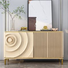 an art deco sideboard with a painting on the wall next to it and a plant