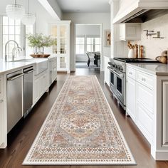 a large rug is in the middle of a kitchen with white cabinets and stainless steel appliances