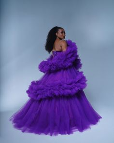 a woman wearing a purple dress with ruffles