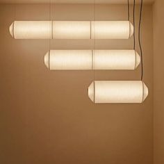 several lights hanging from the ceiling in a room with beige walls and brown flooring