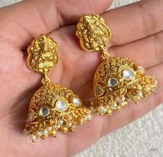 Luxurious Temple Jhumka earrings are a stunning example of South Indian jewelry, featuring intricate Kundan and Polki work. Plated in 22k gold for a regal finish, the earrings are adorned with delicate pearls for a timeless touch. The antique design evokes traditional elegance, perfect for special occasions. *𝐏𝐑𝐎𝐃𝐔𝐂𝐓 𝐃𝐄𝐓𝐀𝐈𝐋* * Material:  Brass  * Plating:  22K Antique Gold Plated *DIMENSIONS* * Weight 17 gm Each *𝐃𝐈𝐒𝐂𝐋𝐀𝐈𝐌𝐄𝐑* Product color may slightly vary due to photograp Traditional Jhumka, Antique Jhumka, Jewelry Kundan, Polki Earrings, South Indian Jewelry, Kundan Earrings, India Jewelry, Jhumka Earrings, Pearl Earring