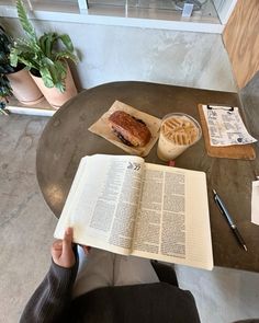 an open book sitting on top of a table next to a sandwich and waffle