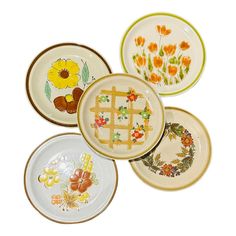 four plates with flowers painted on them are arranged in the shape of a flower wreath