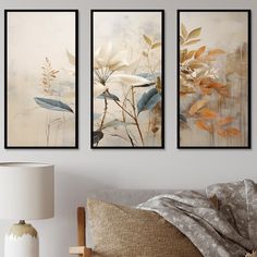 three framed art prints hanging on the wall above a bed with a pillow and lamp