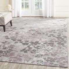 an area rug with flowers on it in front of a white door and window sill