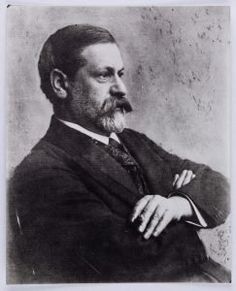 an old black and white photo of a man in a suit with his arms crossed