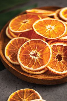 sliced oranges sitting on top of a wooden plate