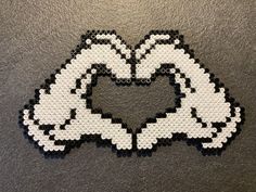 a heart made out of legos sitting on top of a table next to a black and white wall