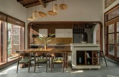 an open kitchen and dining room area with large windows on both sides, surrounded by wood paneling