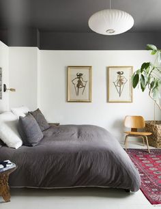 a bedroom with two paintings on the wall