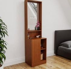 a bedroom with a bed, mirror and plant on the floor in front of it