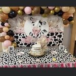 a table topped with a cake and balloons