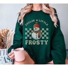 "Warm up your winter style with our \"Feelin' Frosty\" Snowman Sweatshirt! ❄️⛄ This sweatshirt is a snow-nostalgic blast from the past, blending retro vibes with your favorite frosty friend, Mr. Snowman! ⏳🎅 Featuring a vintage-inspired design and crafted for ultimate comfort, this Christmas sweatshirt will keep you cozy and in the holiday spirit all season long. 🎄✨ It's the perfect addition to your funny winter wardrobe, and trust us, you'll be the jolliest snowman on the block! 🎁🤶 So, don't Snow Nostalgic, Snowman Sweatshirt, Frosty Snowman, Shirt Knot, Retro Christmas Shirt, Snowman Sweater, Sweater Season, Print Ideas, Blast From The Past