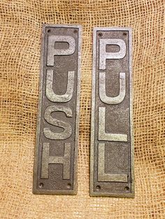 two metal signs that say push and pull on burlocked fabric with jumbo bag in the background