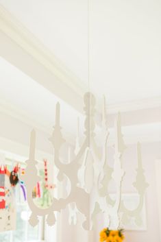 a white chandelier hanging from the ceiling in a room with sunflowers