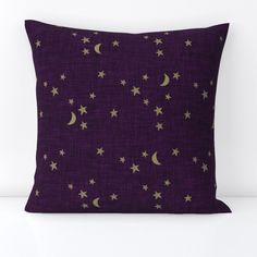 a purple pillow with gold stars and moon on it