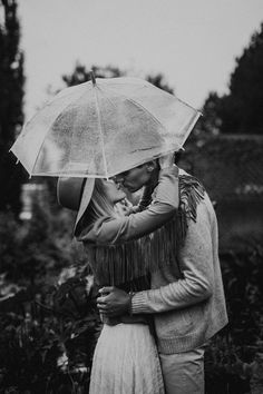 a man and woman embracing under an umbrella