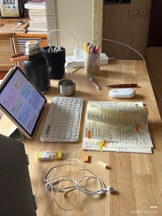 a wooden table topped with lots of electronic devices and accessories on top of it's surface