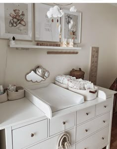 a baby's crib in the corner of a room with pictures on the wall