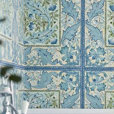 a bathroom with blue and green tiles on the wall