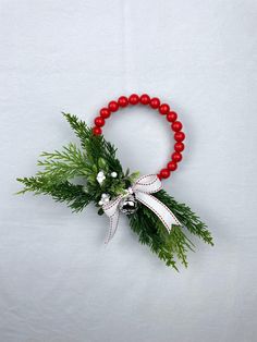 a red beaded bracelet with white flowers and greenery