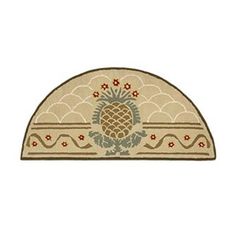 an oval rug with pineapples and flowers in the center on a white background