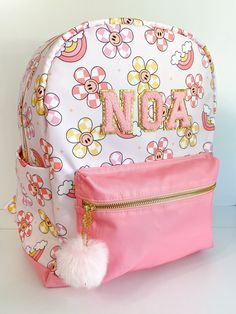 Welcome to Noa Jayne Co where we specialize in personalized backpacks for kids and toddlers! All backpacks are fully customizable and come with sewn on patches to ensure long lasting durability. Our backpacks are perfect for daycare, school, traveling, and make for the cutest diaper bag. The perfect personalized gift for kids! We've even recently designed our OWN backpacks from top to bottom! You're looking at one now! Backpack *Fits children who are over 45" tall *Overall: 13" wide x 6" deep x 16" tall  *All gold hardware and zippers *Nylon waterproof fabric *Cup holders on both sides *Interior zipper pocket *Two pom pom keychains included (white and pink) *Leather bottom *Noa Jayne Co EXCLUSIVE backpack design - you won't find this backpack anywhere else! Personalization Details *All pat Playful Pink Backpack With Zipper Closure, Customizable Pink Backpack For School Events, Customizable Pink Backpack For Students, Cute Standard Backpack For School Events, Customizable Cute Bags For School Events, Customizable Cute Backpack For School Events, Cute Customizable Bags For Back To School, Personalized Pink Bag For Daycare, Cute Customizable Standard Backpack