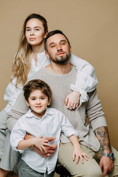 a man and woman sitting next to a little boy