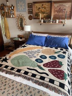 a bed with a quilt on top of it and pictures hanging above the headboard