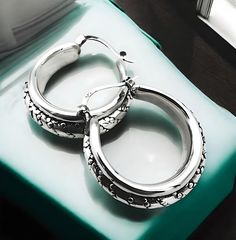 Elevate your jewelry collection with our exquisite 925 Sterling Silver Caviar Design Hoop Earrings. These elegant earrings showcase a sophisticated latch-back closure, ensuring both security and comfort. The hollow form construction provides a lightweight feel without compromising on style. Each earring is meticulously crafted to measure approximately 1.078 inches (27.5 mm) in width and 1.047 inches (26.6 mm) in length, offering a substantial presence while maintaining an air of delicacy. The caviar design adds a touch of luxury and texture, making these hoops a versatile addition to any outfit, whether casual or formal. Proudly stamped with '925' to affirm the purity of the silver used, these earrings are a testament to quality craftsmanship and enduring design. Elevate your accessory the Silver Engraved Hoop Earrings For Anniversary, Engraved Silver Hoop Earrings For Anniversary, Sterling Silver Engraved Hoop Earrings For Anniversary, Engraved Sterling Silver Hoop Earrings For Anniversary, Anniversary Hoop Earrings With Sterling Silver Clasp, Anniversary Hoop Earrings In Sterling Silver, Silver 925 Stamped Hoop Earrings For Anniversary, Small Hoop Earrings With Sterling Silver Clasp For Anniversary, 925 Stamped Small Hoop Earrings For Anniversary