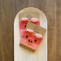 two pink knitted items are on a white plate with a brown tag attached to it