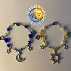 two bracelets that have charms on them and one has a sun, moon, and stars