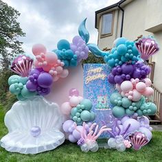 there are balloons and mermaid decorations on the lawn