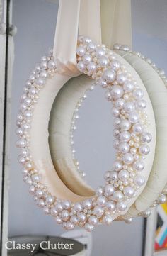 three white wreaths with pearls hanging from them