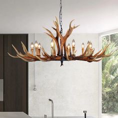 a deer antler chandelier hangs over a kitchen counter