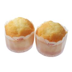 two muffins sitting next to each other on top of plastic wrappers in front of a white background