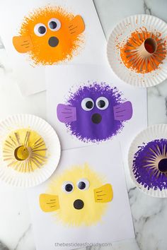 three paper plates with different colored animal faces on them, one is orange and the other is purple