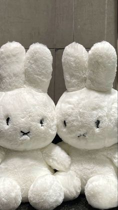 two white stuffed animals sitting next to each other